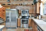 A fully supplied kitchen will allow you to make homecooked meals at Black Bear Cabin.